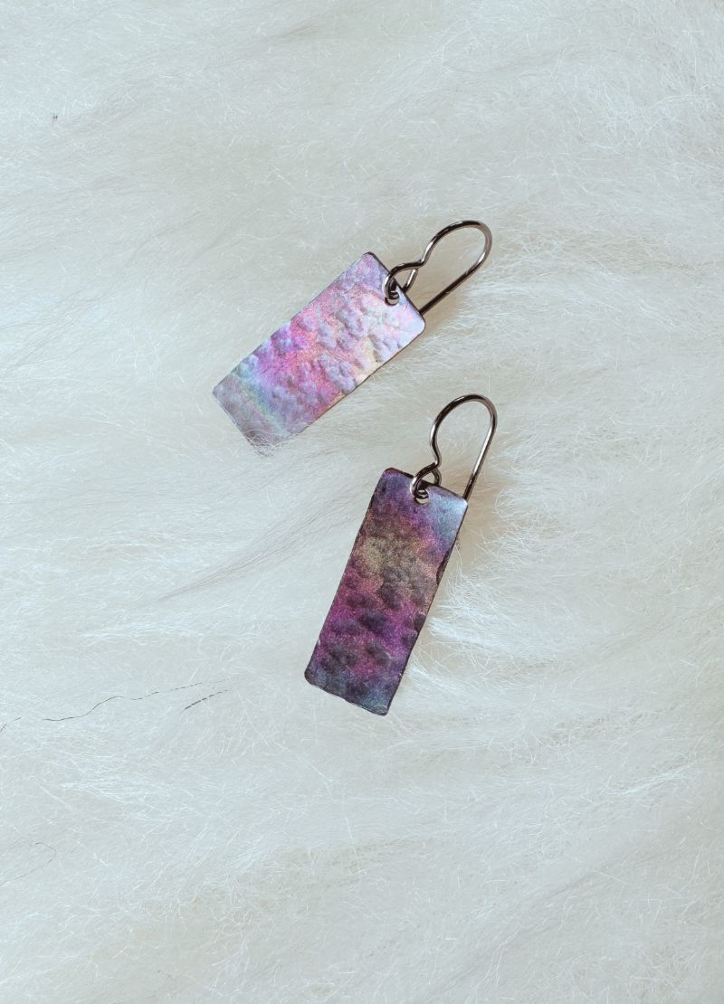 Pair of earrings with multi colour design on a white background