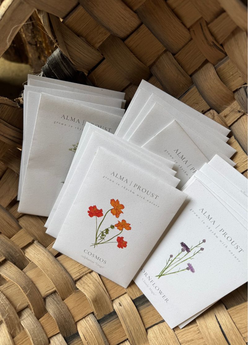 Small packets of seeds with floral designs on a woven basket
