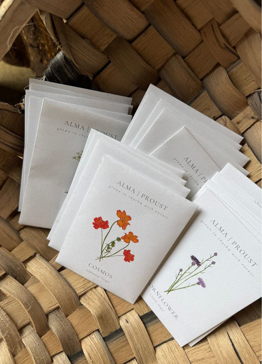 Small packets of seeds with floral designs on a woven basket