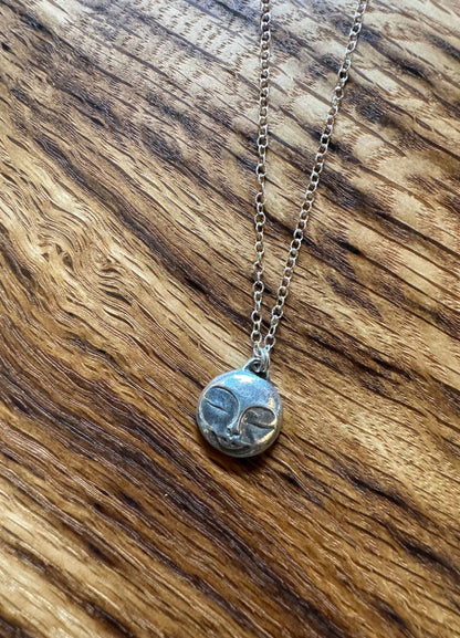 Necklace with a small pendant on a wooden surface