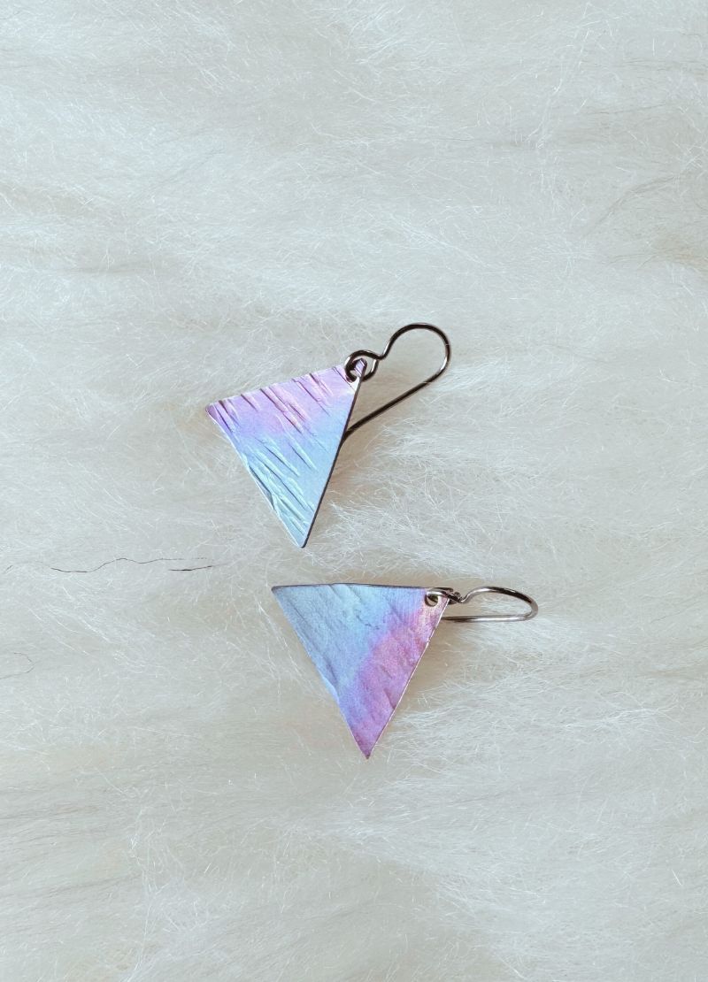 Triangular earrings with a gradient color on a light background