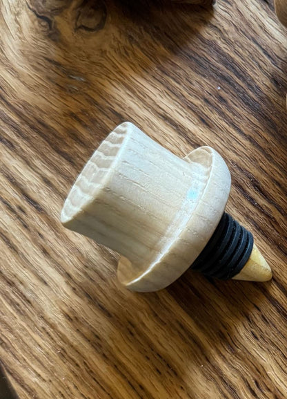 Wooden bottle stopper with a black rubber gasket on a wooden surface